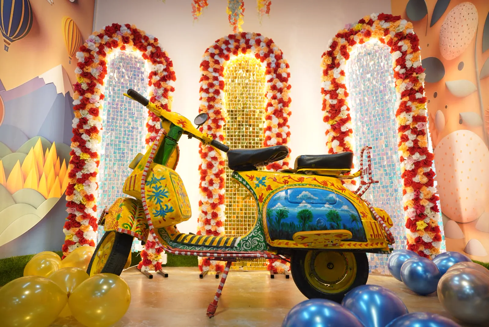 Detailed view of a decorated scooter and illuminated floral arches in a sample celebration setup
