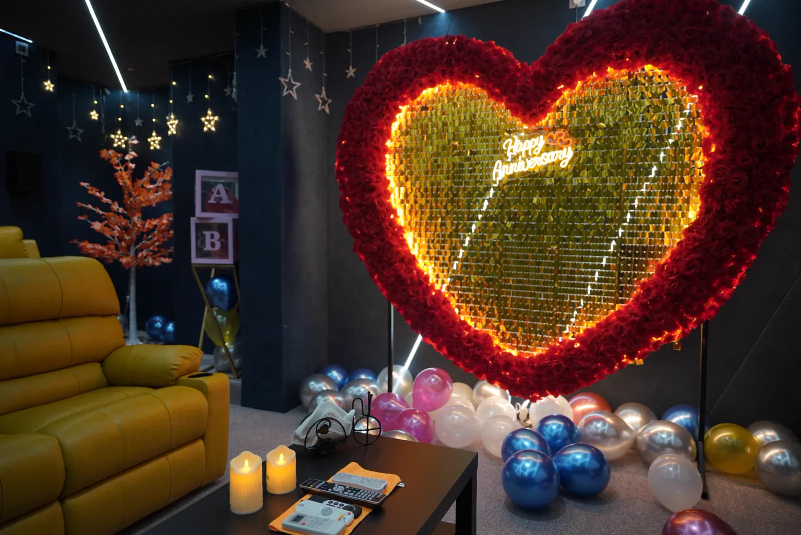 Couple theatre sample with yellow recliner, illuminated heart backdrop and balloon decoration