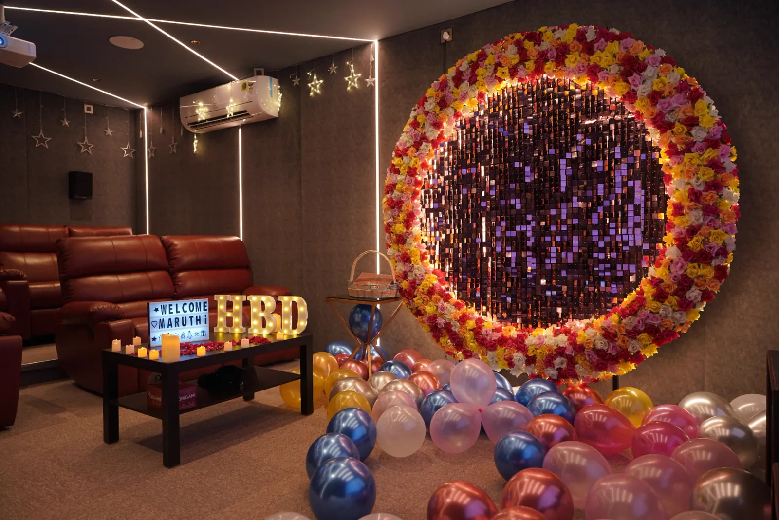 Sample mini theatre setup with tiered recliner seating, wall speakers, air conditioning and birthday decoration